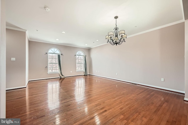 unfurnished room with hardwood / wood-style flooring, crown molding, and a notable chandelier