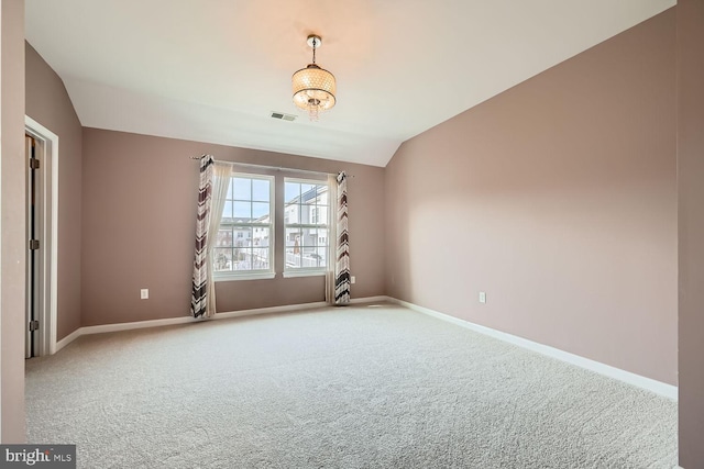 empty room featuring lofted ceiling and carpet