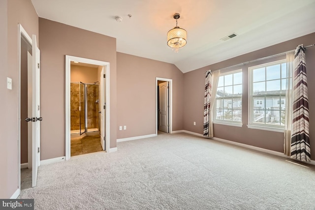 unfurnished bedroom featuring lofted ceiling, light carpet, and ensuite bath