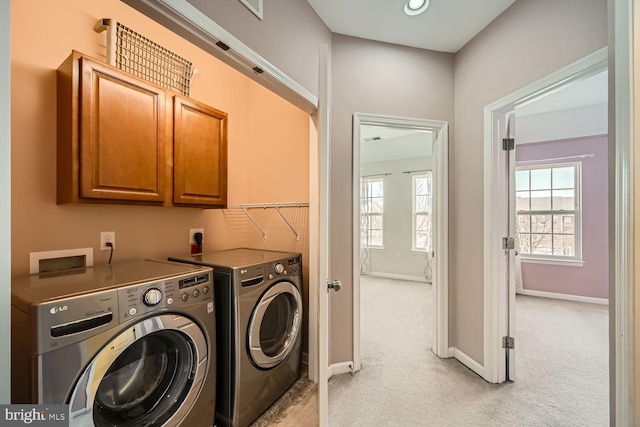 clothes washing area featuring cabinets, separate washer and dryer, and light carpet