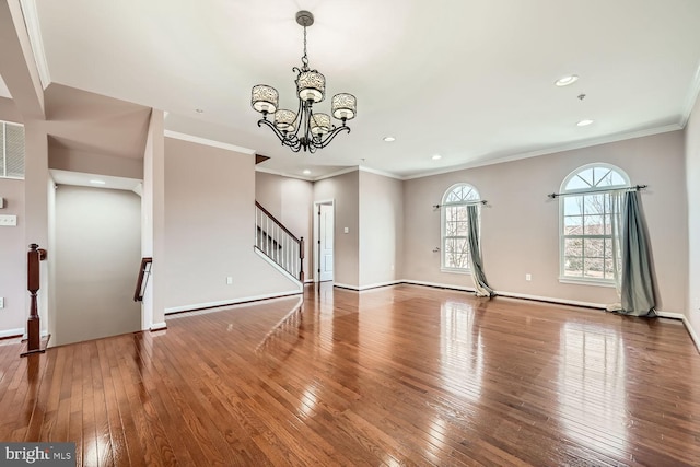 unfurnished living room with crown molding, wood-type flooring, and a chandelier