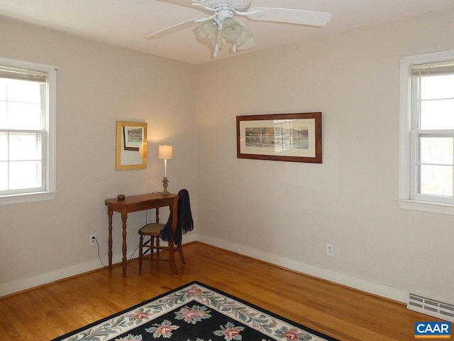 home office featuring hardwood / wood-style flooring, ceiling fan, and plenty of natural light