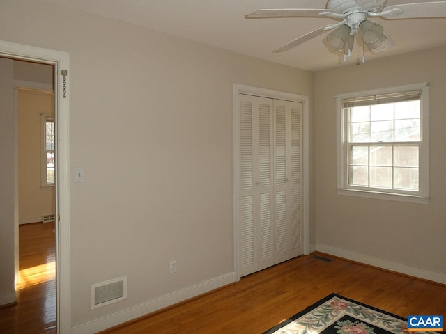 unfurnished bedroom featuring ceiling fan, hardwood / wood-style floors, and a closet