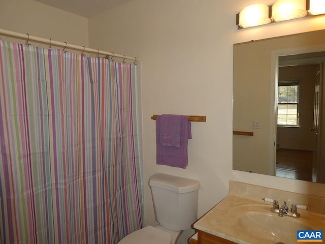 bathroom with vanity, curtained shower, and toilet