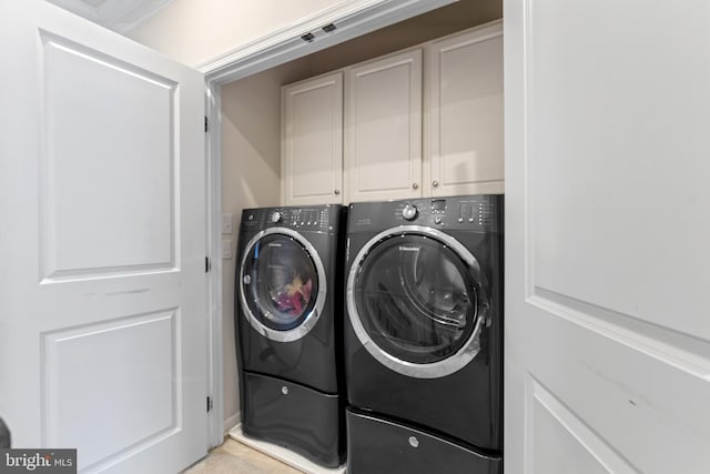 laundry area featuring cabinets and washing machine and clothes dryer