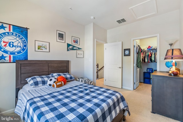 carpeted bedroom featuring a spacious closet and a closet