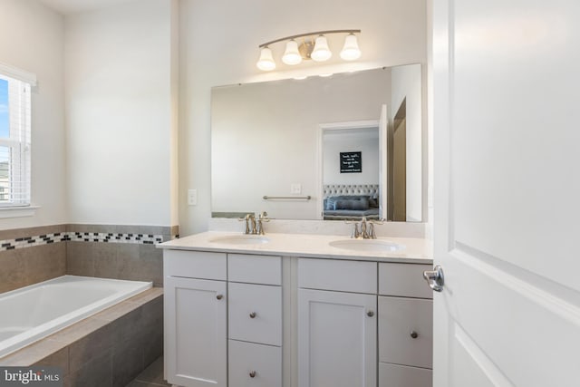 bathroom featuring vanity and tiled tub