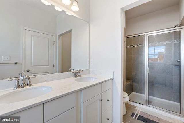 bathroom featuring a shower with door, vanity, tile patterned floors, and toilet