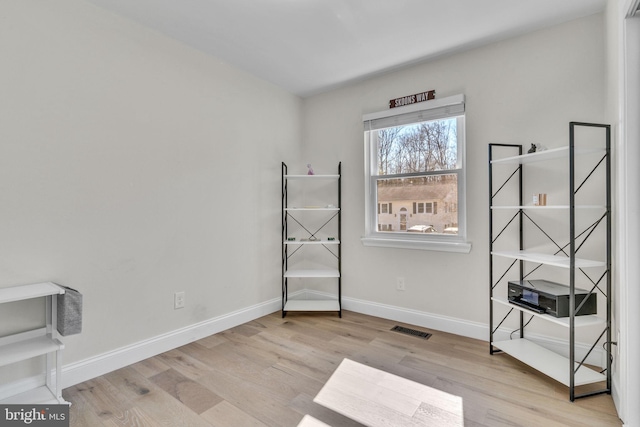 misc room with light wood-type flooring, visible vents, and baseboards