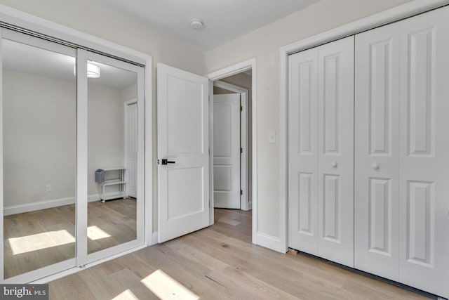 unfurnished bedroom with light wood-style flooring and baseboards