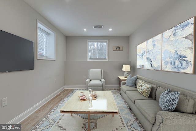 living room featuring light wood-type flooring, visible vents, baseboards, and recessed lighting