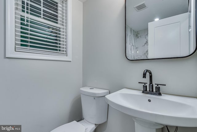 bathroom featuring visible vents, a sink, and toilet