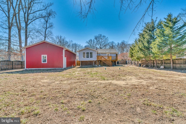 rear view of house with a fenced backyard and a lawn