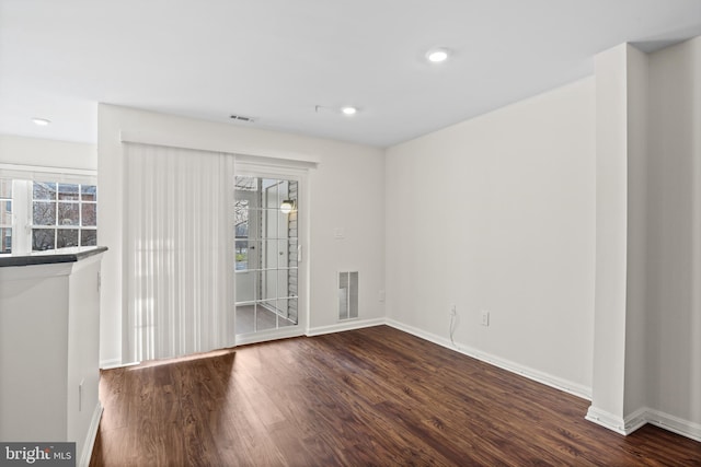 unfurnished room with dark wood-type flooring