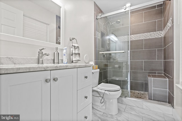 bathroom with vanity, a shower with shower door, and toilet