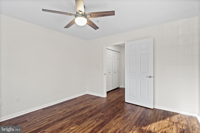 unfurnished bedroom with dark hardwood / wood-style flooring, a closet, and ceiling fan