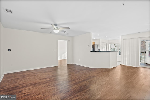 unfurnished living room with dark wood-type flooring and ceiling fan