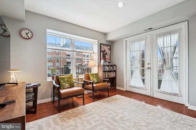 sitting room with wood-type flooring, a healthy amount of sunlight, and french doors