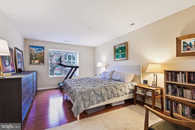 bedroom with dark hardwood / wood-style floors