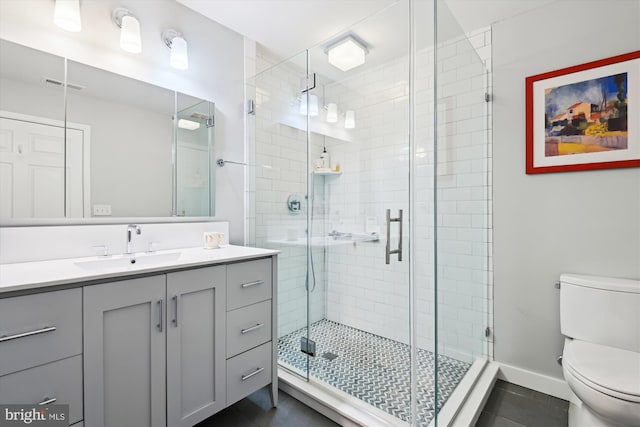 bathroom featuring vanity, tile patterned floors, toilet, and walk in shower