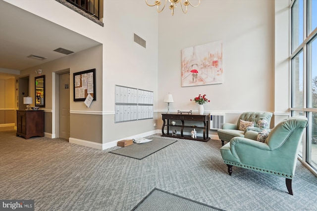 interior space featuring carpet floors, a high ceiling, and a mail area