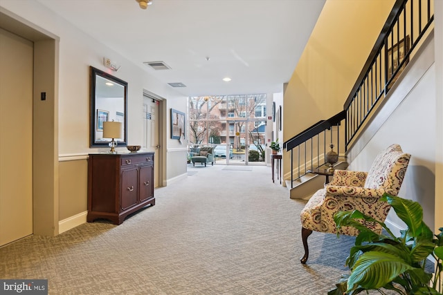 corridor with elevator and light carpet