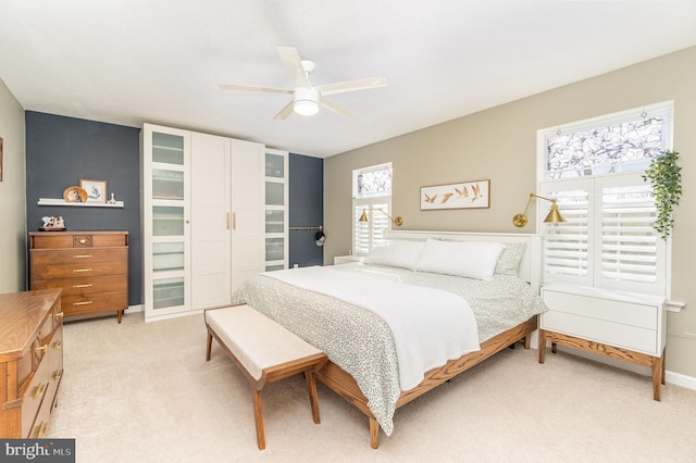 carpeted bedroom with ceiling fan and multiple windows