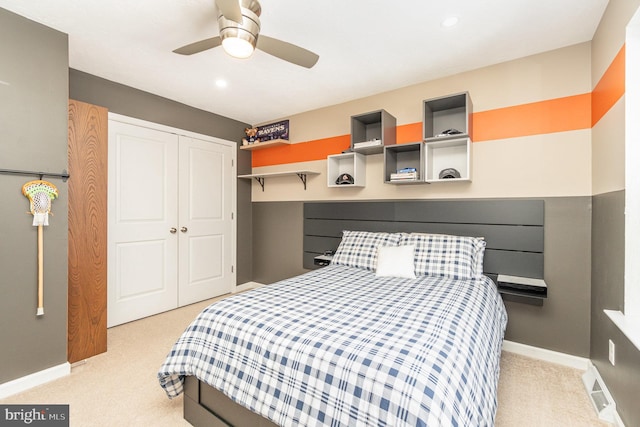 bedroom featuring light carpet, ceiling fan, and a closet