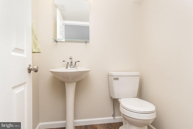 bathroom with wood-type flooring and toilet