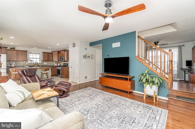 living room with ceiling fan and light hardwood / wood-style floors