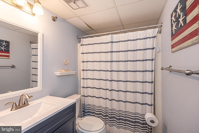 bathroom with a paneled ceiling, vanity, toilet, and a shower with shower curtain