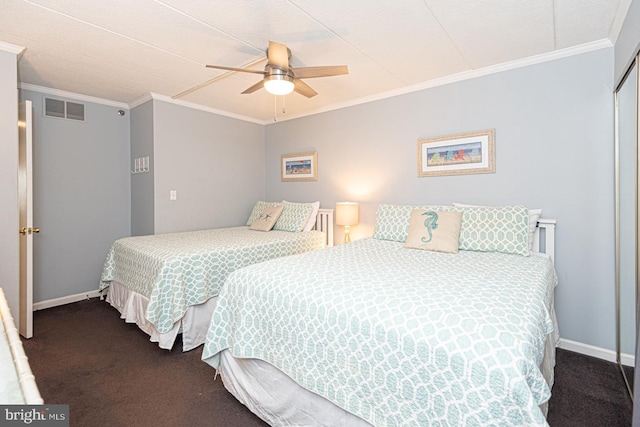 bedroom featuring ornamental molding, ceiling fan, dark carpet, and a closet