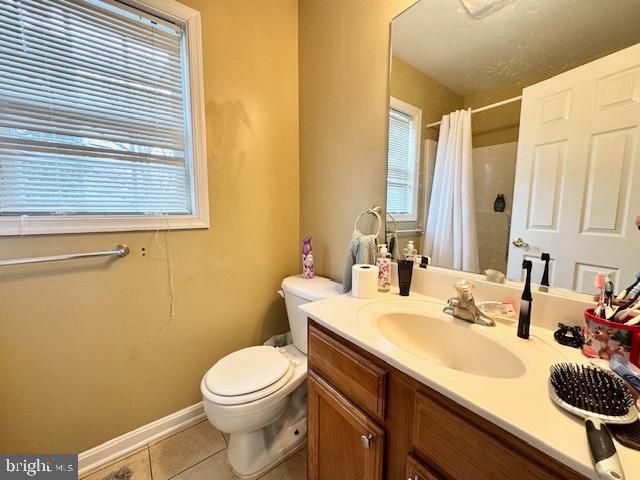 bathroom featuring tile patterned flooring, vanity, toilet, and a shower with shower curtain