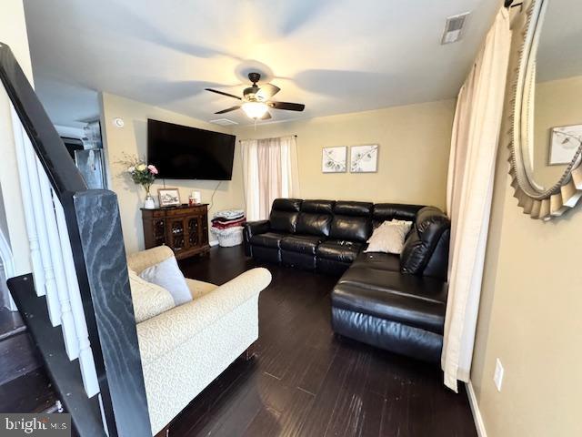 living room with ceiling fan and dark hardwood / wood-style flooring