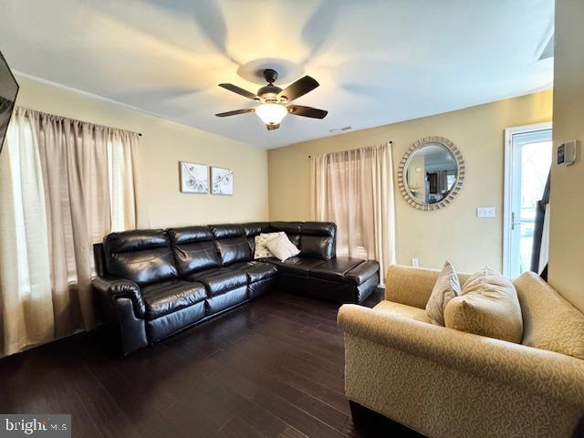 living room featuring dark hardwood / wood-style flooring and ceiling fan