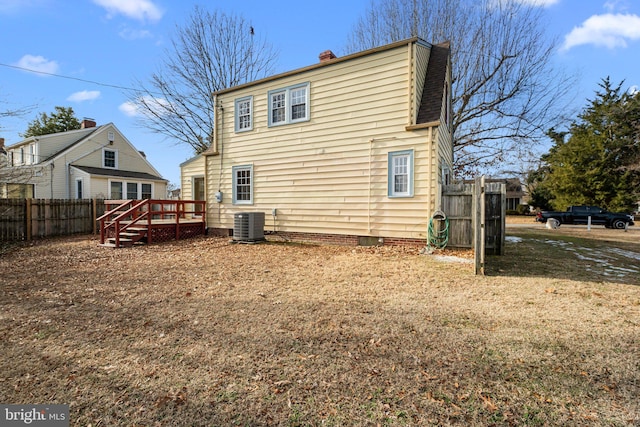 back of property with central AC and a deck