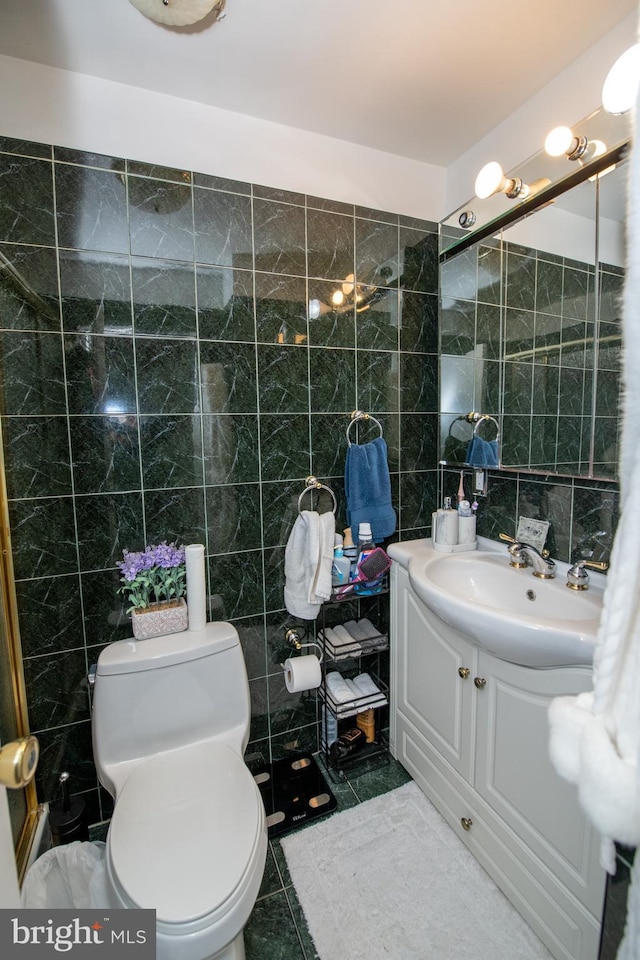 bathroom featuring vanity, toilet, tile patterned flooring, and tile walls