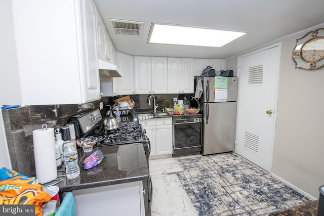 kitchen with sink, dark stone countertops, stainless steel appliances, white cabinets, and decorative backsplash