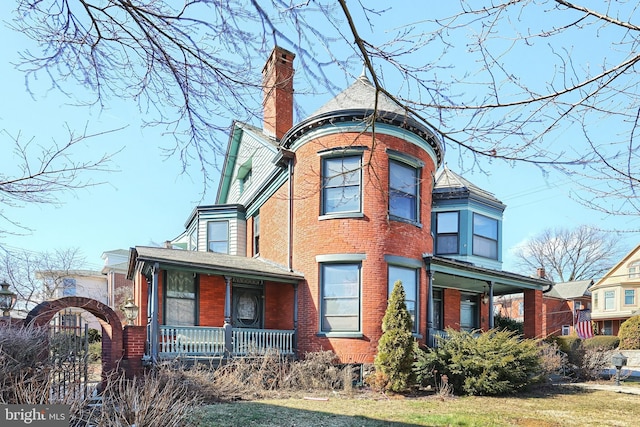 victorian home with covered porch and a front lawn