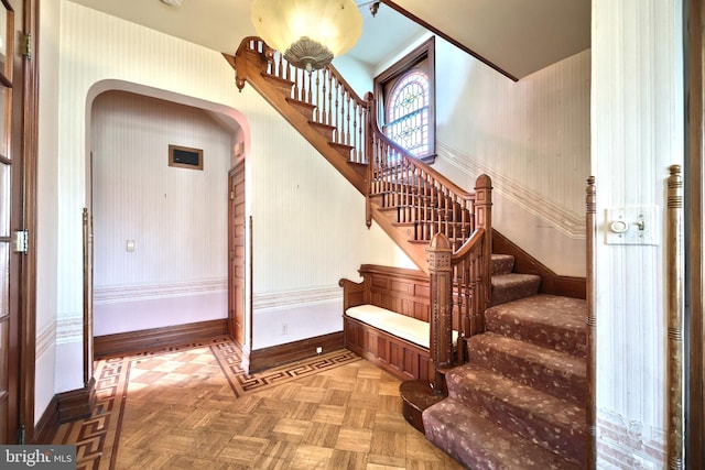 staircase featuring parquet flooring