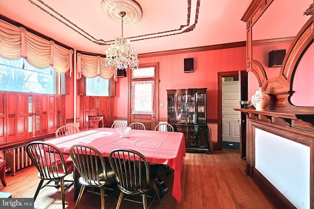 dining room with ornamental molding, dark wood-type flooring, and a chandelier