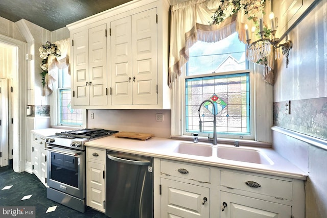 kitchen with sink, appliances with stainless steel finishes, and white cabinetry