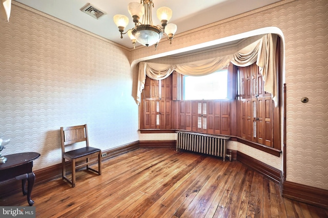 sitting room featuring radiator, a notable chandelier, and hardwood / wood-style flooring