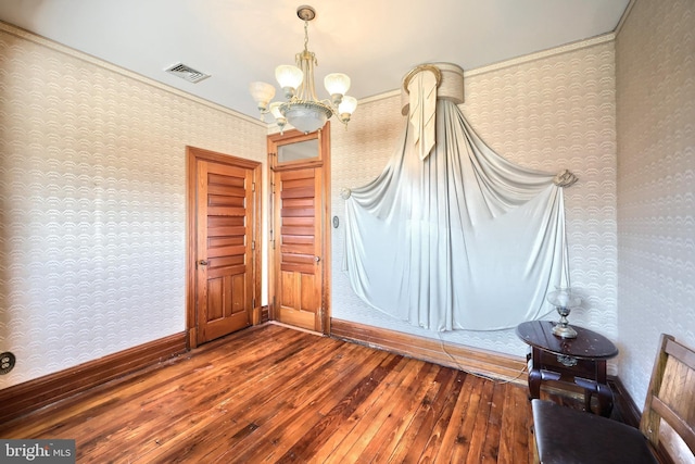 unfurnished room with an inviting chandelier and wood-type flooring