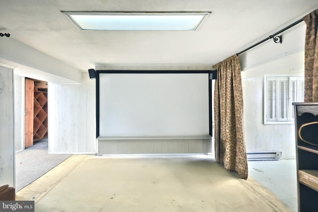 cinema room with concrete flooring and baseboard heating