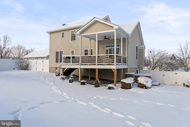 snow covered house with central AC and ceiling fan