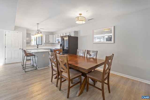 dining area featuring sink and light hardwood / wood-style flooring