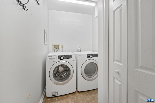 washroom with light tile patterned floors and washing machine and dryer