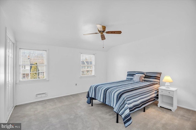 carpeted bedroom featuring multiple windows and ceiling fan