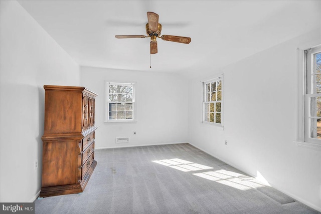 carpeted empty room featuring ceiling fan